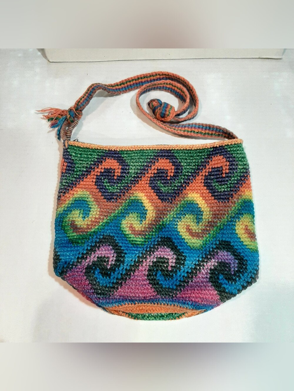 Colorful crochet crossbody bag features a vibrant multicolored wave pattern